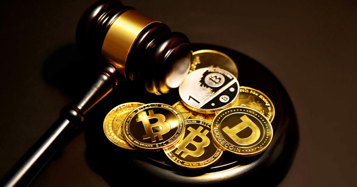 A wooden judge gavel resting next to physical golden Bitcoin and Dogecoin tokens representing VARA marketing regulations UAE legal compliance