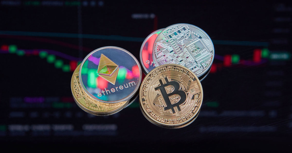 Physical Bitcoin and Ethereum coins placed over financial trading charts representing crypto asset tracing UAE and blockchain investigations